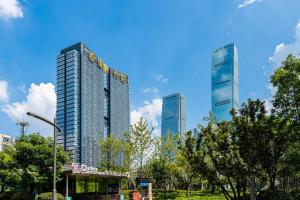 dwa wysokie budynki w mieście z drzewami w obiekcie 悠闲的时光 w mieście Changsha