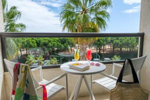 a balcony with a table with a cake and two glasses at Estival Isla Cristina in Isla Cristina