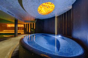 クライペダにあるVICTORIA Hotel Klaipėdaの時計付きの客室内のジャクジーバスタブ +37枚の写真