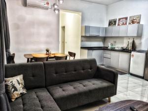 sala de estar con sofá y mesa en la cocina en MsHome Suite Equnie Residence @ Taman Equnie Seri Kembangan, en Seri Kembangan