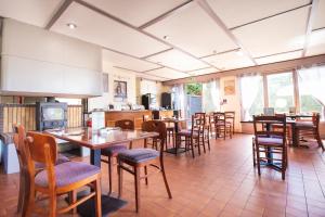a restaurant with tables and chairs and a kitchen at Campanile Hotel Doncaster in Doncaster