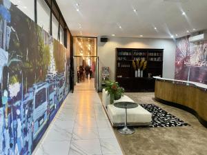 a lobby with a waiting room with a table and posters at Reef Hotel in Johannesburg