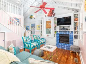 een woonkamer met blauwe stoelen en een tv bij Island Bliss in Tybee Island