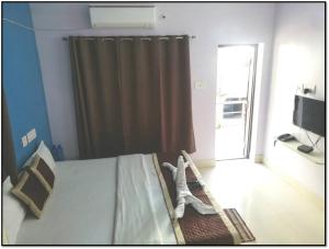 a bedroom with a bed with a curtain and a window at Railview inn Bhubaneswar in Bhubaneshwar +23 photos