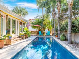 een zwembad in de achtertuin van een huis met palmbomen bij Island Bliss in Tybee Island