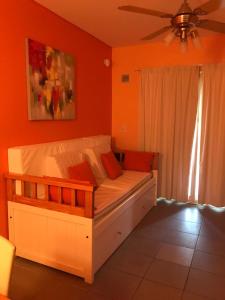 1 dormitorio con 1 cama grande y pared de color naranja en Cozzani en Pinamar