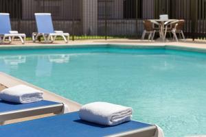 a swimming pool with blue chairs and towels at La Quinta Inn by Wyndham Temple in Temple