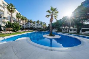 una gran piscina con una palmera en el medio en Estival Isla Cristina, en Isla Cristina