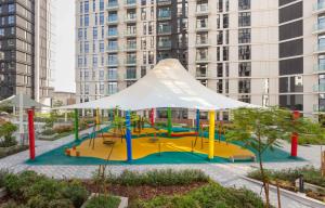 einen Spielplatz in einer Stadt mit hohen Gebäuden in der Unterkunft Expo Village Serviced Apartments in Dubai