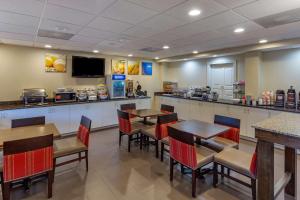 a restaurant with tables and chairs and a counter at Comfort Suites Raleigh Walnut Creek in Raleigh