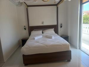 a bedroom with a large bed with white sheets at Maranda Deluxe Double Seaview room - B&B with pool. in Ukunda
