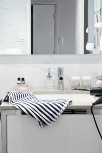 a white kitchen with a sink and a striped towel at Hôtel 2170 Lincoln Downtown Montreal in Montréal