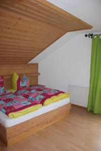 Schlafzimmer mit Holzbett und Holzdecke in der Unterkunft Pension Sonneneck in Zwiesel