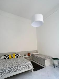 a bedroom with two beds and a white wall at B&B Casa Caracciolo in Naples