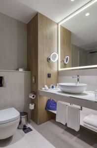 uma casa de banho com um lavatório, um WC e um espelho. em Radisson Blu Hotel, Kyiv City Centre em Kiev