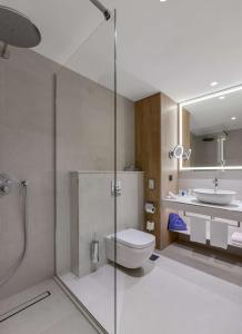 een badkamer met een douche, een toilet en een wastafel bij Radisson Blu Hotel, Kyiv City Centre in Kiev