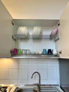 a kitchen with a sink and a shelf with dishes at B&B Casa Caracciolo in Naples