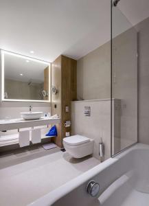 a bathroom with a tub and a toilet and a sink at Radisson Blu Hotel, Kyiv City Centre in Kyiv