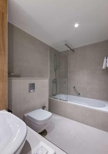a bathroom with a toilet and a tub and a sink at Radisson Blu Hotel, Kyiv City Centre in Kyiv