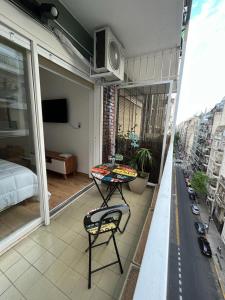 een klein balkon met een tafel en een bed op een balkon bij Refugio cómodo y luminoso. Excelente ubicación. in Buenos Aires
