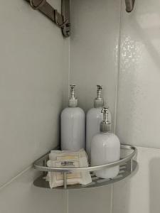 un estante con tres botellas de jabón en el baño en Refugio cómodo y luminoso. Excelente ubicación. en Buenos Aires