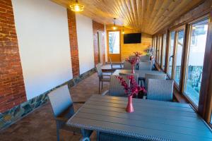 a dining room with tables and chairs and a television at Pensiunea Matei in Petroşani