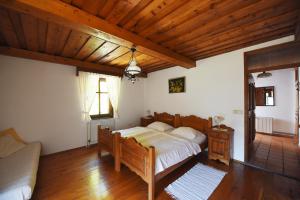 ein Schlafzimmer mit einem Bett und einem Sofa darin in der Unterkunft Domačija Šeruga in Novo Mesto