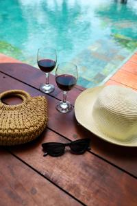 una mesa con dos copas de vino y un sombrero y gafas de sol en River Arc, en Panadura