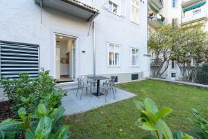 a patio with a table and chairs in a yard at Premium Apartments im Stadtzentrum in Graz