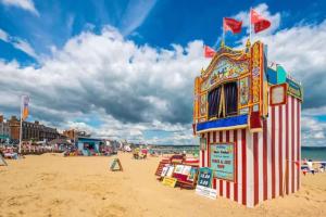 a lifeguard station on a beach with people on it at Green Sails House in Weymouth