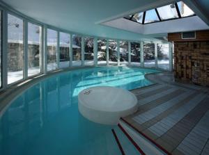 a large swimming pool with a toilet in the middle at Hotel la Brunerie in Les Deux Alpes