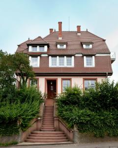 ein Haus mit einer Treppe, die zur Eingangstür führt in der Unterkunft Wohnen im alten Pfarrhaus in Herbolzheim