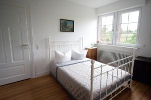 1 dormitorio con 1 cama blanca y 2 almohadas en Wohnen im alten Pfarrhaus, en Herbolzheim