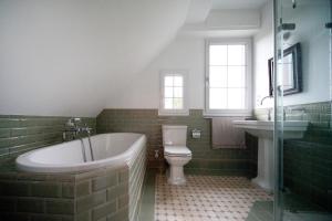 a bathroom with a tub and a toilet and a sink at Wohnen im alten Pfarrhaus in Herbolzheim