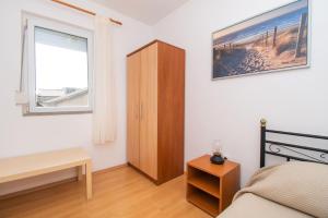 - une chambre avec un lit, une armoire et une fenêtre dans l'établissement Apartment Sokol, à Batalaži