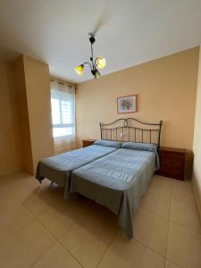 a bedroom with a bed with a blue comforter and a window at Alpen1 Argenta/Caleta in Peniscola