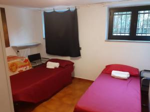Duas camas num quarto com uma janela em Taverna tranquillissima indipendente em Trezzano sul Naviglio