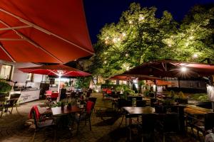 an outdoor restaurant with tables and umbrellas at night at Sauerländer Hof in Eslohe