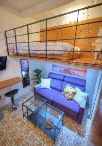 ein Wohnzimmer mit einem blauen Sofa und einem Etagenbett in der Unterkunft Cozy & cute studio in the heart of Valletta GOVAL2 in Valletta