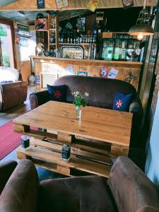 a table in a bar with a couch and a table at Hôtel Restaurant l’Éolienne in Rouxmesnil-Bouteilles