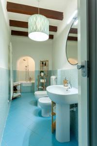 een badkamer met een wastafel, een toilet en een spiegel bij A central quiet place in Verbania in Verbania