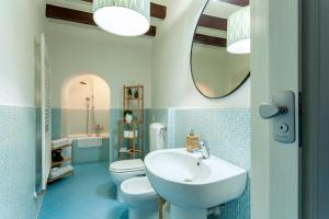 een badkamer met een wastafel, een toilet en een spiegel bij A central quiet place in Verbania in Verbania