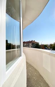 a window in a white wall with a view of a city at Business & Family Apartment for 6 Guests with Free Parking in Stara Zagora