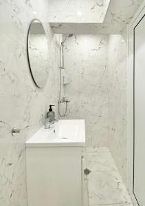 Baño blanco con lavabo y espejo en Business & Family Apartment for 6 Guests with Free Parking, en Stara Zagora