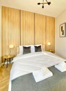 a bedroom with a large white bed with wooden walls at Business & Family Apartment for 6 Guests with Free Parking in Stara Zagora
