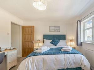 a bedroom with a bed with two towels on it at Crug Y Bar in Gwbert