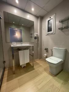 a bathroom with a toilet and a sink and a mirror at SM Hotel Teatre Auditori in Barcelona