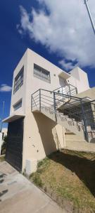 a white building with a staircase on the side of it at C&M Alquiler temporario y Rent a Car in Las Heras