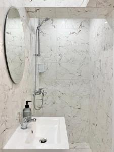Baño blanco con lavabo y espejo en Business & Family Apartment for 6 Guests with Free Parking, en Stara Zagora