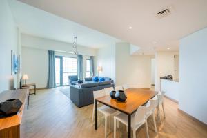 un soggiorno con tavolo e divano di Expo Village Serviced Apartments a Dubai